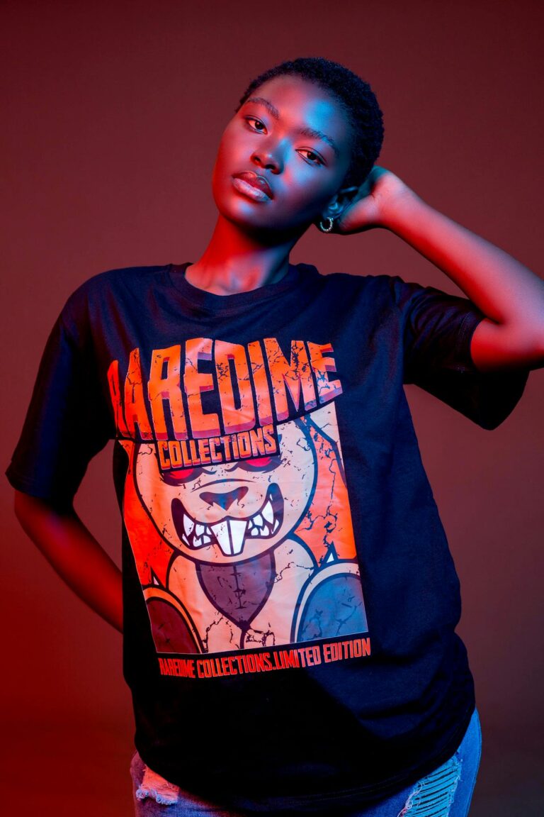 Stylish portrait of a woman in a black t-shirt with vibrant design, set against a red background.